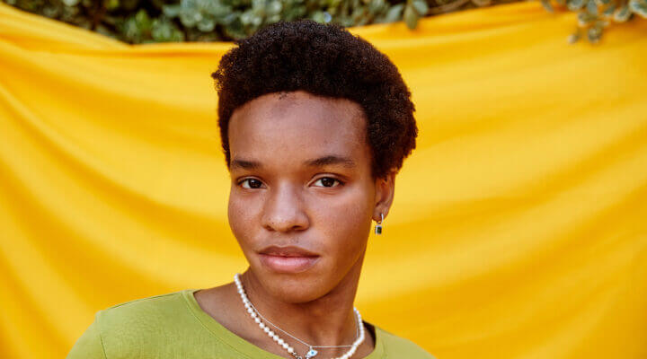 Close-up of a person in front of yellow backdrop.