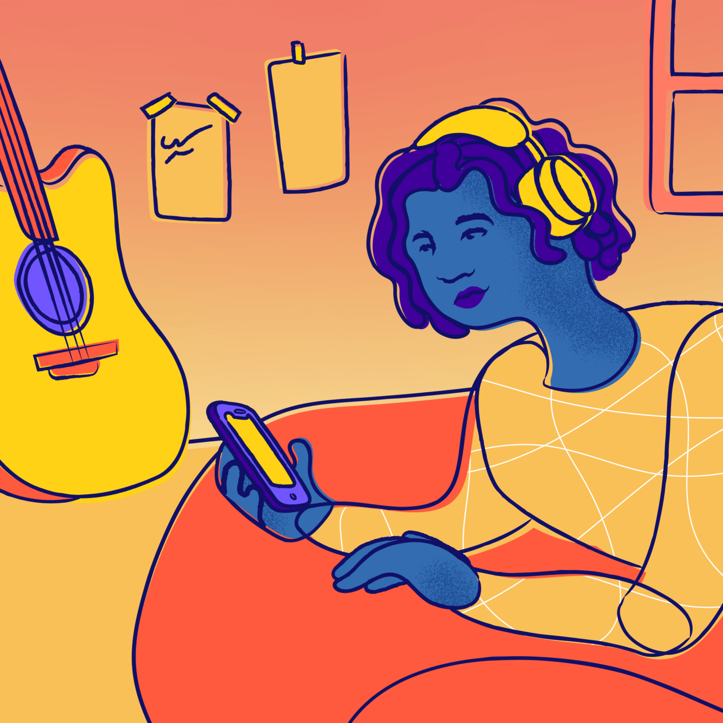 A young person texts on their bed with headphones on, next to a guitar and a window.