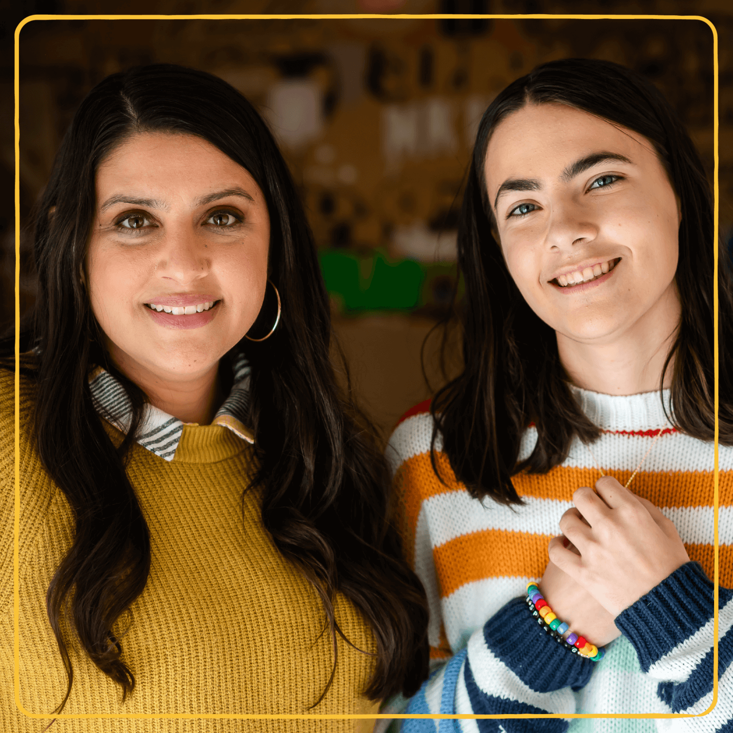 A mentor and LGBTQ+ young person smile at the camera.